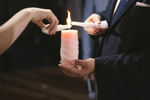 Cérémonie de mariage, attirail, la mariée et le marié tiennent une grande bougie dans leur main. — Photo