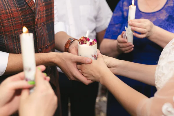 Γαμήλια τελετή, σύνεργα, η νύφη και ο γαμπρός κρατούν ένα μεγάλο κερί στο χέρι τους. — Φωτογραφία Αρχείου