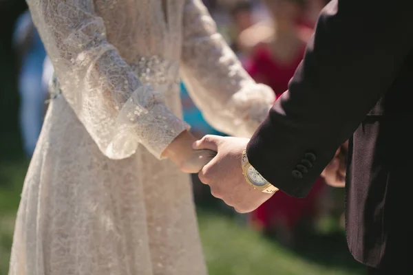 Νύφη και γαμπρός κρατούν τα χέρια κατά τη διάρκεια της τελετής γάμου. — Φωτογραφία Αρχείου