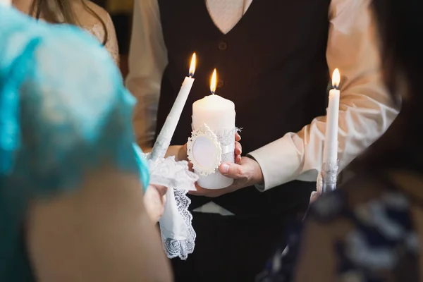 Hochzeitszeremonie, Utensilien, Braut und Bräutigam halten eine große Kerze in der Hand. — Stockfoto