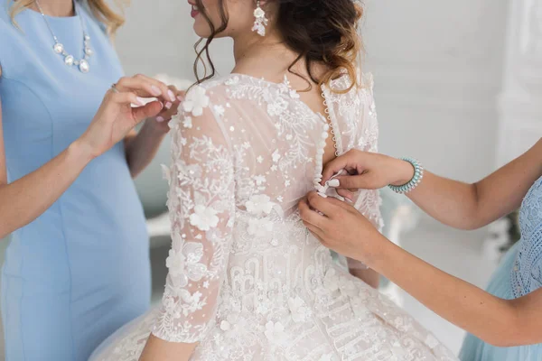 Mani femminili pulsante l'abito da sposa per la sposa con una bella acconciatura . — Foto Stock