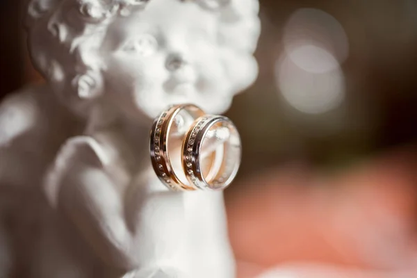 Soška anděla se svatebními zlatými prsteny. — Stock fotografie