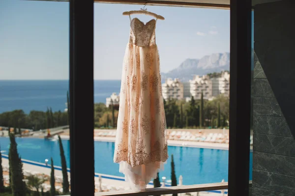 Vestido de novia en el hotel en el fondo de la piscina, el océano y las montañas —  Fotos de Stock