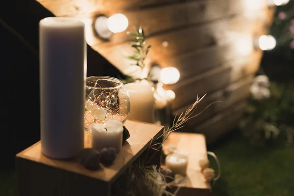 Prachtige houten fotozone in de vorm van een hart met gloeiende gloeilampen, kaarsen en een zigeuner in een vaas — Stockfoto