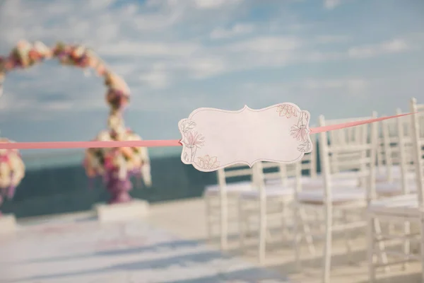 En skylt mot bakgrund av bröllopsbågen och havet — Stockfoto