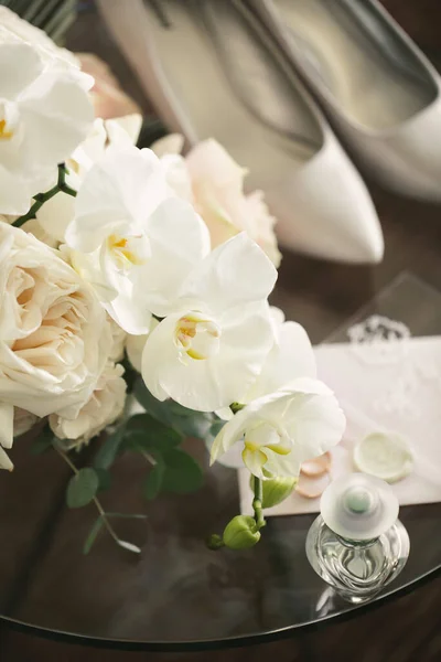 Elegante ramo de rosas y orquídeas, zapatos y accesorios de la novia de cerca — Foto de Stock