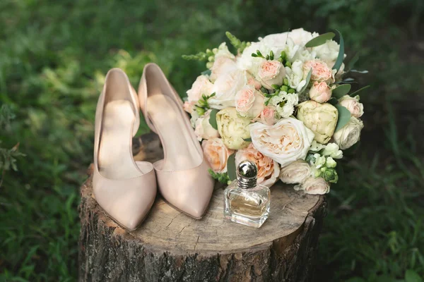 Belo buquê nupcial de rosas brancas em um toco de madeira. Elegante, sapatos de couro bege noiva. Casamento em estilo vintage. — Fotografia de Stock