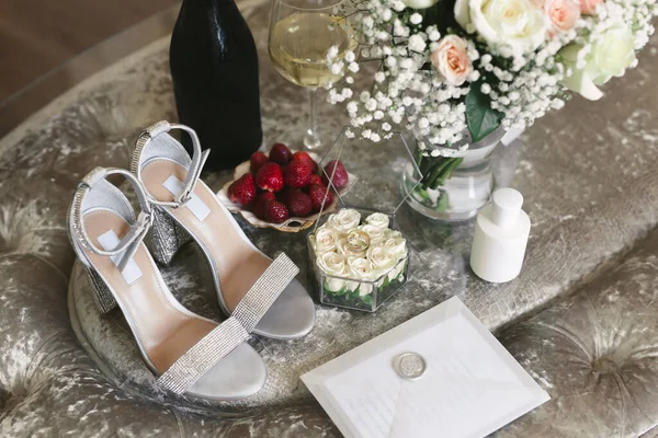 Ráno nevěsty ve svatební den: boty, prstýnky, šampaňské, jahody a kytici — Stock fotografie