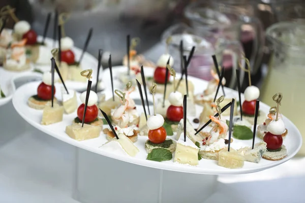 Catering table buffet dinner, beautifully decorated banquet with variety of different food snacks and appetizers on corporate birthday party event or wedding reception, canape, delicatessen setting. — Stock Photo, Image