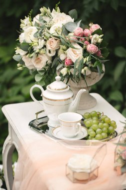 Gelinlerin düğün günü toplantıları için romantik fotoğraf bölgesi. Ormanda masa, çiçekler ve gül yaprakları