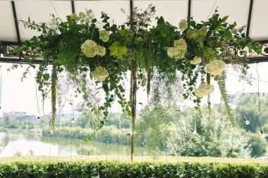 Ayrıntılar. Çiçeklerin açık havasında, mumlarla düğün töreni. Yeni evliler için nazik ve güzel bir düğün dekoru.