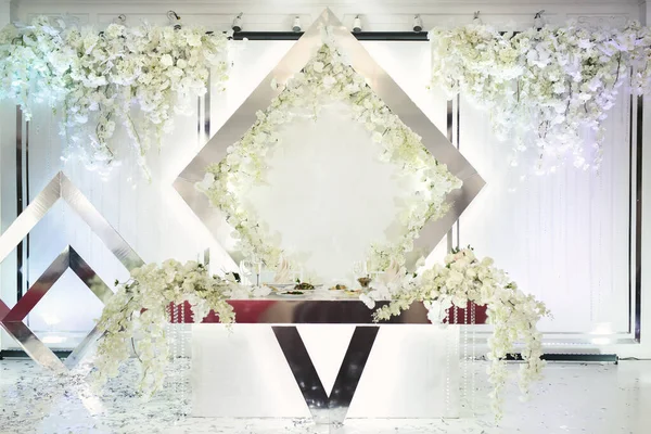 Una pared decorada con las iniciales del nombre y flores cerca de la mesa de comedor de la boda. — Foto de Stock