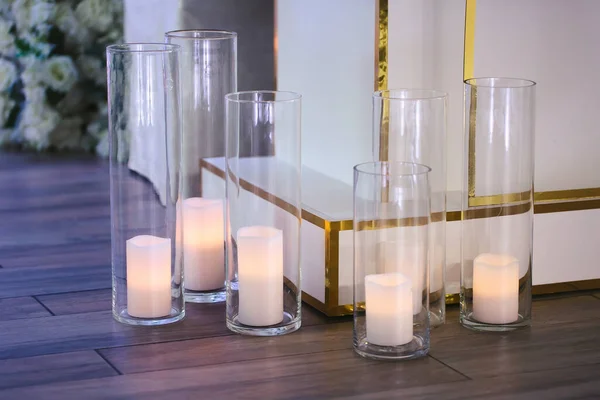 Queimar velas brancas em vasos de vidro no chão. A decoração acolhedora da cerimônia de casamento — Fotografia de Stock