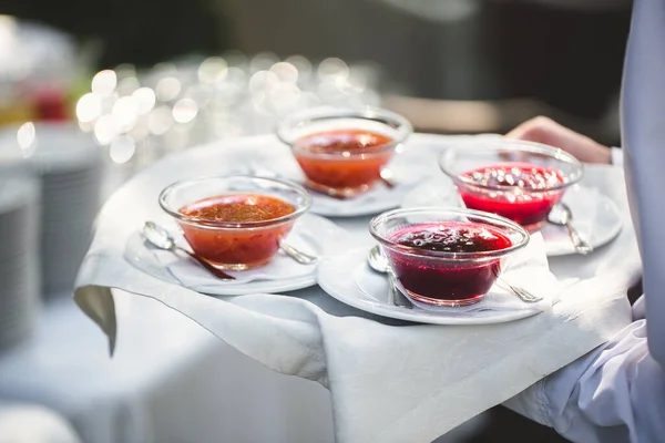 Bobule a ovocný džem na podnose v rukou číšníka — Stock fotografie