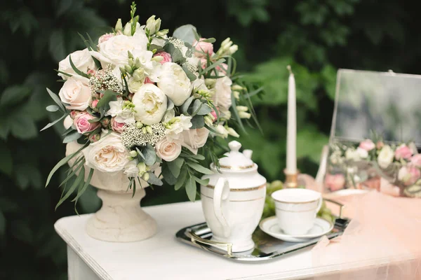 Natura morta mattina della sposa, un piatto con una tazza di tè, un portagioie, fedi nuziali e un mazzo di fiori. — Foto Stock