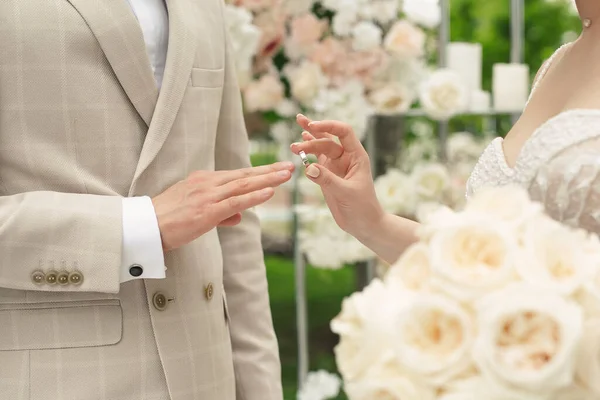 Jegygyűrűk. Egy házaspár eljegyzési gyűrűt cserél egy esküvői ceremónián. A menyasszony gyűrűt húzott a vőlegény ujjára. — Stock Fotó