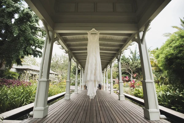 En lyxig bröllopsklänning hänger i lusthuset på bröllopsdagen — Stockfoto