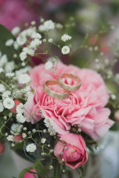 Anillos de boda de oro en un ramo de flores frescas — Foto de Stock