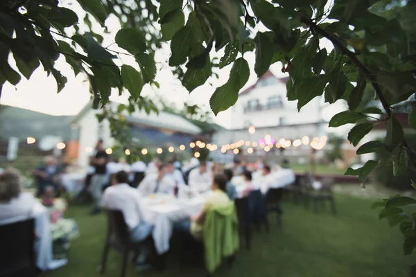 Gün batımında dışarıda düğün yemeği. Konukların masaları