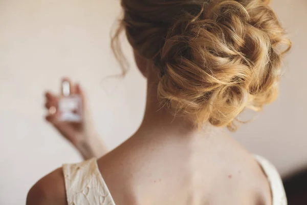 Blonďatá nevěsta si užívá parfém během přípravy svatby — Stock fotografie
