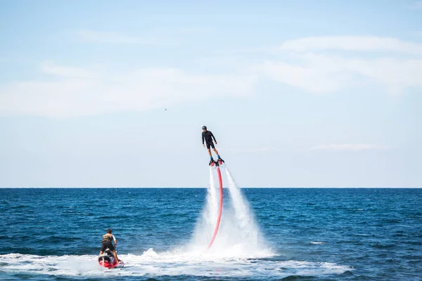 En ryttare på en flyboard i havet gör svåra stunts. — Stockfoto
