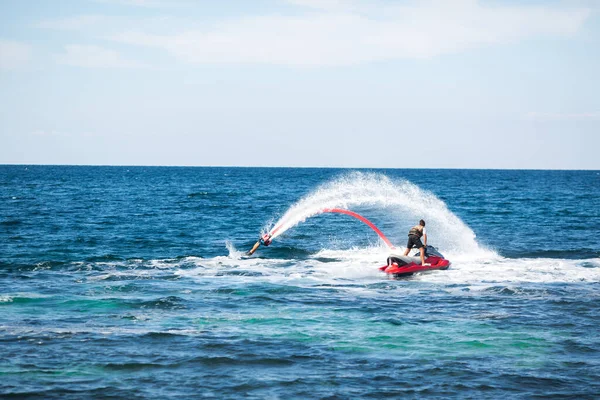 A rider on a flyboard in the ocean does difficult stunts. — Stock Photo, Image