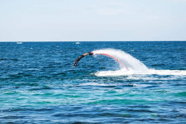 Um cavaleiro em um sobrevoo no oceano faz acrobacias difíceis. — Fotografia de Stock