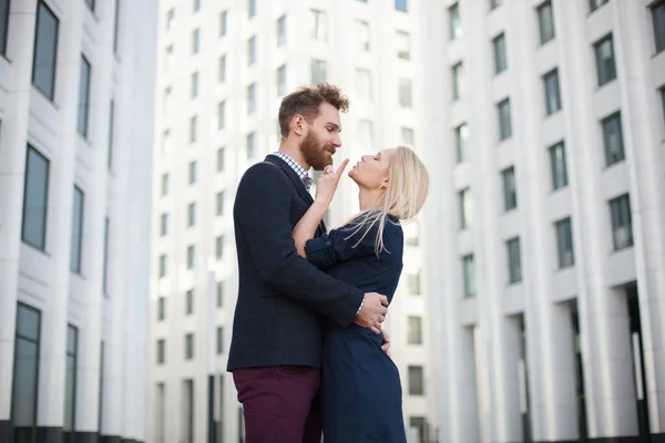 Homem e mulher abraçando e rindo na frente de um prédio branco — Fotografia de Stock