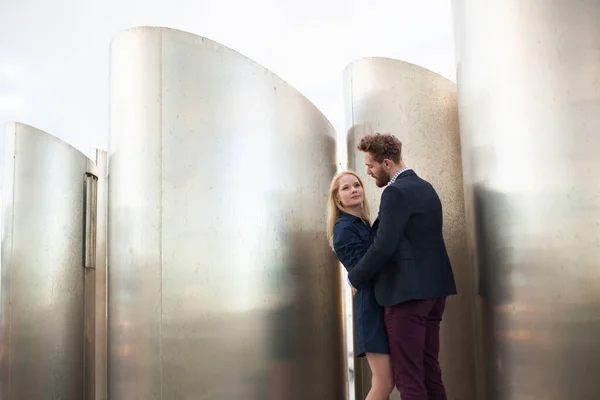 Mann und Frau posieren vor den großen Metallrohren. — Stockfoto