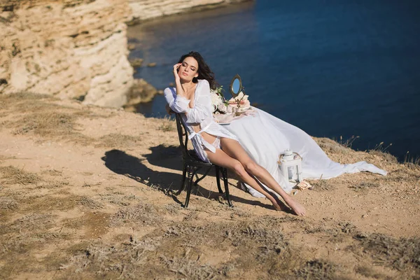 Meisje in lingerie op een berg met uitzicht op de oceaan. Aanklachten van de bruid, bruidsmorgen — Stockfoto