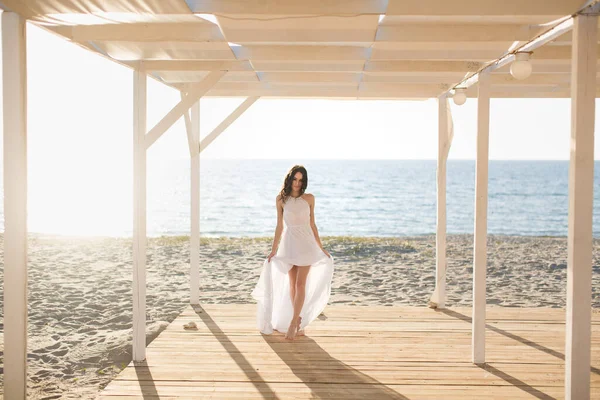 Mooi meisje op het strand in een witte jurk — Stockfoto