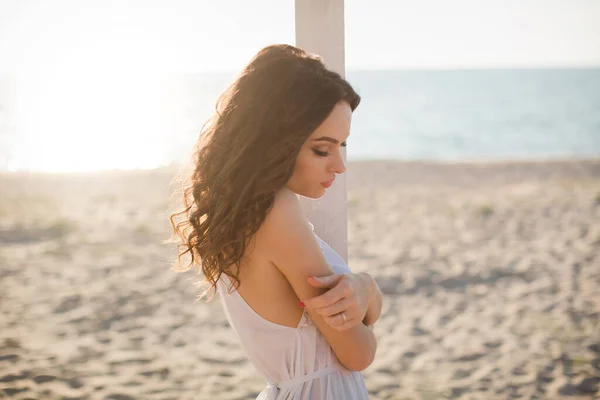 Schöne Mädchen am Strand in einem weißen Kleid — Stockfoto