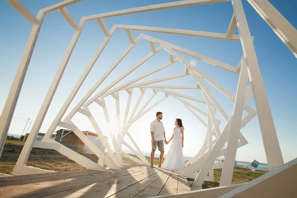 Homem e mulher posando. Estruturas geométricas de madeira. A noiva e o noivo — Fotografia de Stock