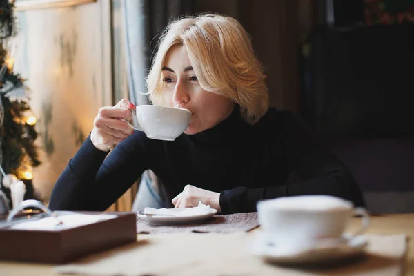 Hermosa mujer bebiendo café en un café. — Foto de Stock