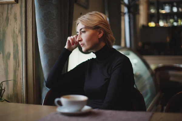 Hermosa mujer bebiendo café en un café. — Foto de Stock