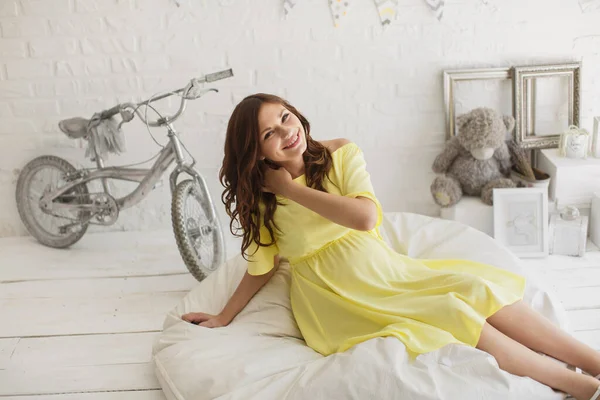 Hermosa mujer embarazada en un vestido amarillo en el estudio — Foto de Stock