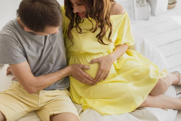 Обрізаний образ красивої вагітної жінки і її красивий чоловік обіймає животик . — стокове фото