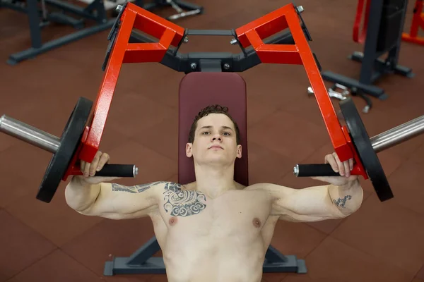 Man doing chest exercises on vertical bench press machine.