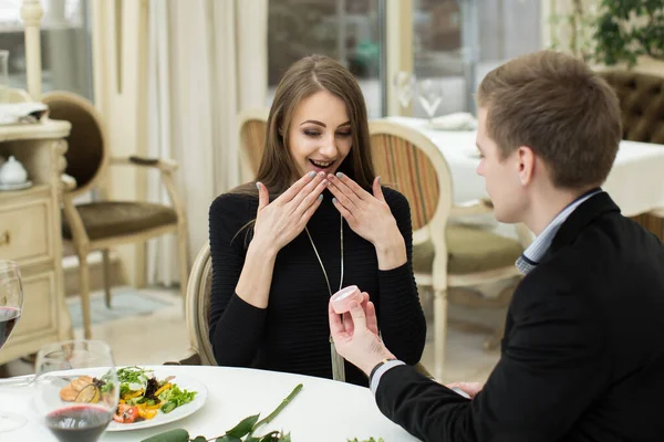 Брачное предложение в ресторане. Мужчина надевает кольцо на женский палец. — стоковое фото