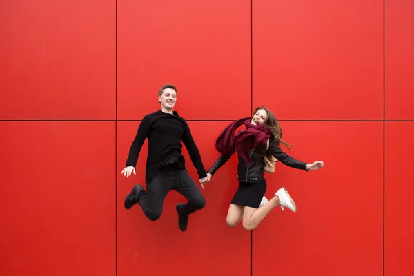 Πήδα. Ένας άντρας και μια γυναίκα σε κόκκινο φόντο. — Φωτογραφία Αρχείου