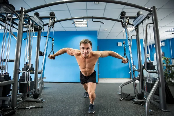 Jonge bodybuilder werkt aan zijn borst met kabel Crossover in Gym. — Stockfoto