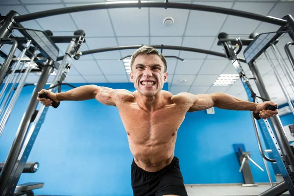 Jonge bodybuilder werkt aan zijn borst met kabel Crossover in Gym. — Stockfoto