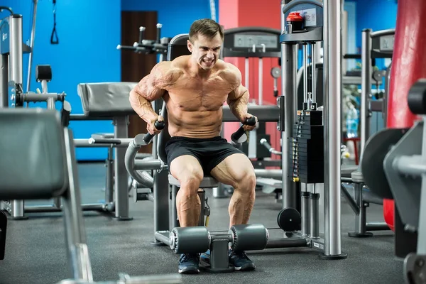 Athletisch starke Bodybuilder turnen in Sporthalle am Stufenbarren. — Stockfoto