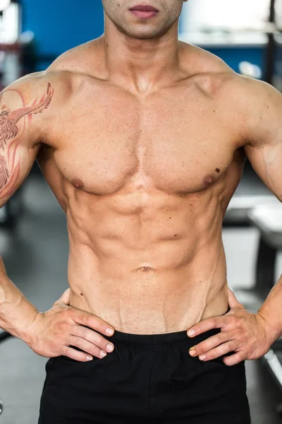 Bodybuilder poserar för kameran i gymmet. — Stockfoto