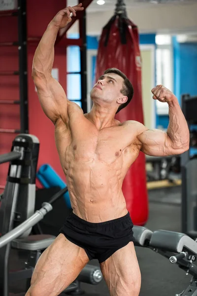 Bodybuilder posiert im Fitnessstudio für die Kamera. — Stockfoto