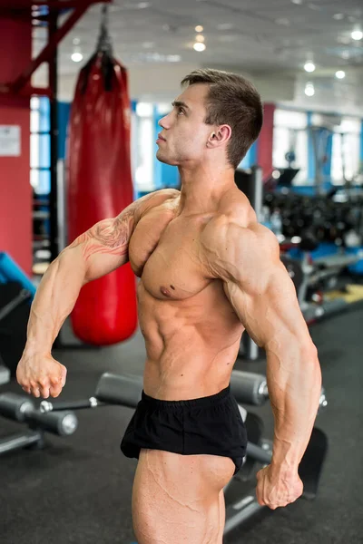 Bodybuilder posiert im Fitnessstudio für die Kamera. — Stockfoto