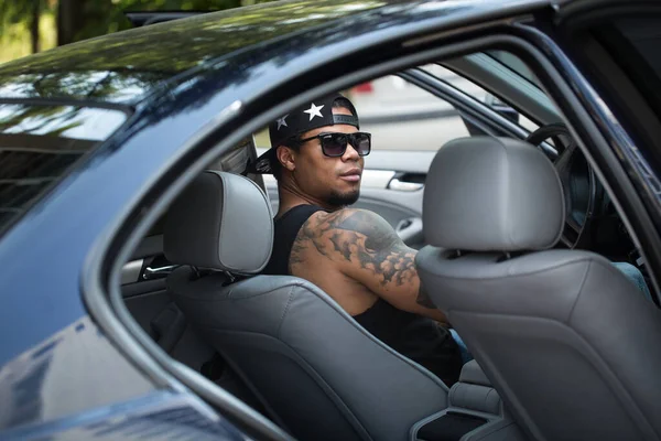 时髦的黑人坐在豪华汽车的轮子后面 — 图库照片