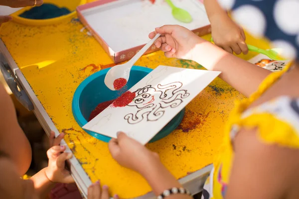 Ребенок рисует цветным песком. Персонажи мультфильмов — стоковое фото