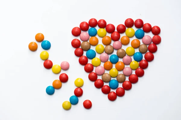 Caramelle di cioccolato a bottone colorate a forma di amore su sfondo bianco . — Foto Stock