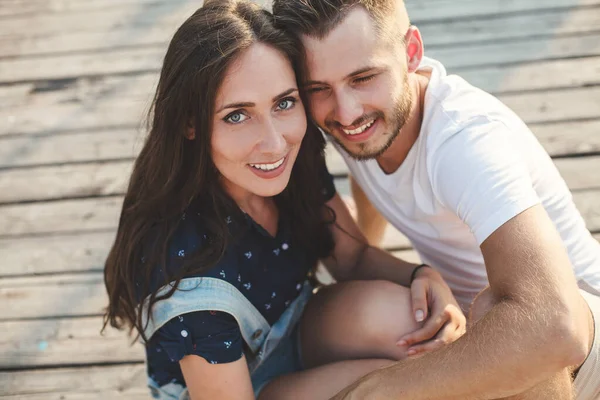 Ragazzo e ragazza, sono seduti su un molo di legno. — Foto Stock